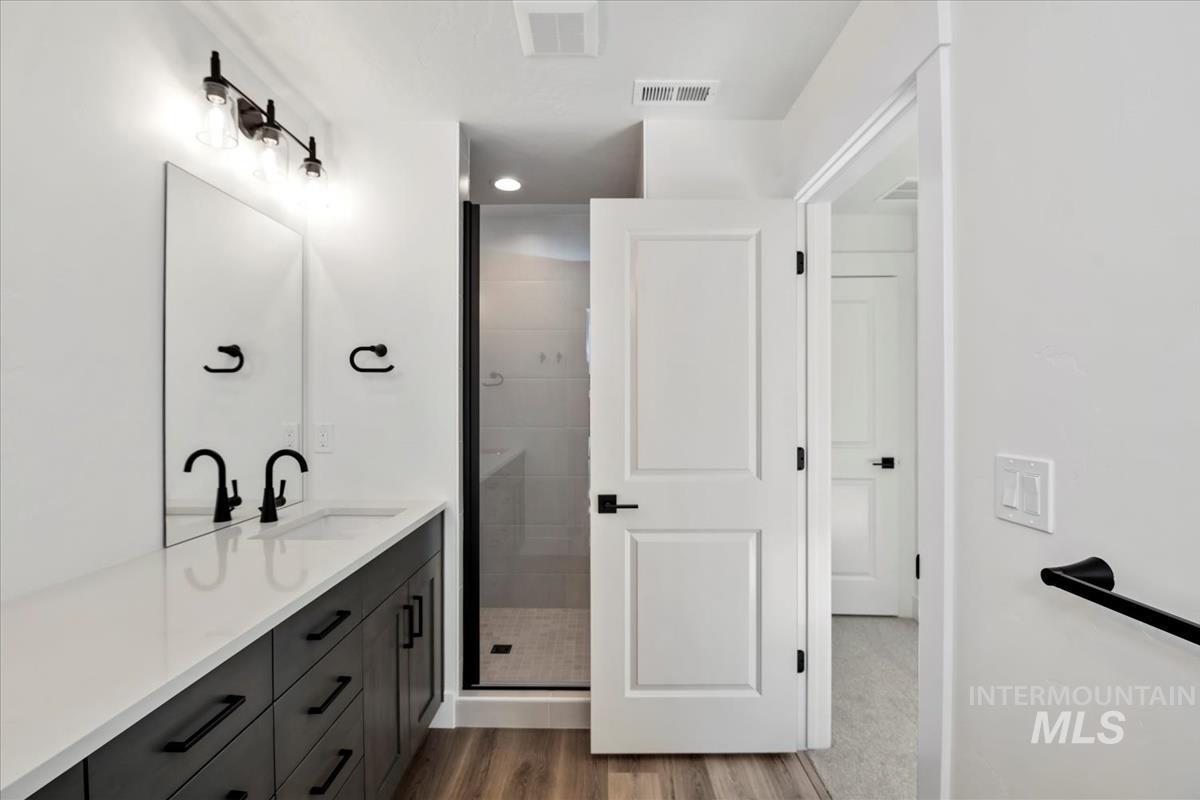 752 South Calhoun Lane Star, ID 83669 - Photo 20 of 45 Bathroom featuring a dual vanity with a white countertop, dark wood-finish cabinetry, and matte black fixtures