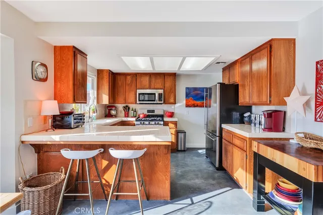 a kitchen with stainless steel appliances a stove a sink dishwasher and a refrigerator