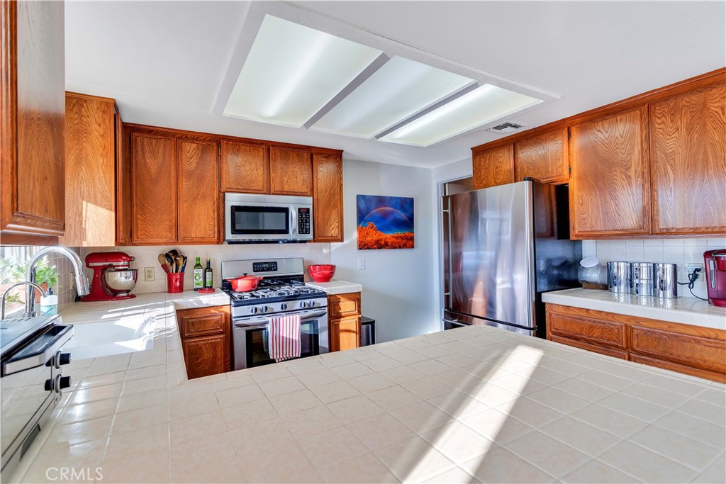 8775 Desert Shadow Road Joshua Tree, CA 92252 - Photo 14 of 39 a large kitchen with stainless steel appliances granite countertop a refrigerator stove top oven a sink and dishwasher