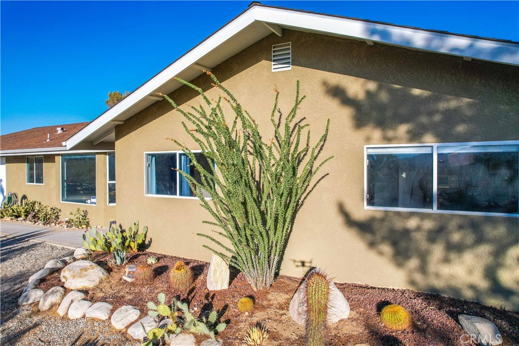 8775 Desert Shadow Road Joshua Tree, CA 92252 - Photo 5 of 39 a front view of a house with garden