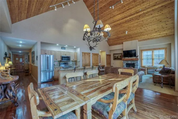 a view of a dining room with furniture a chandelier and wooden floor