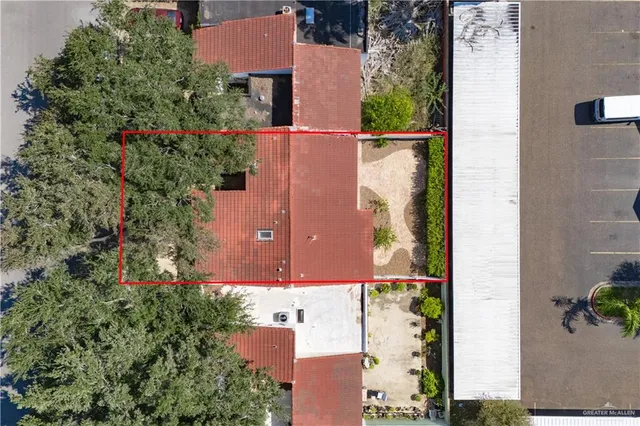 an aerial view of residential houses with outdoor space and trees