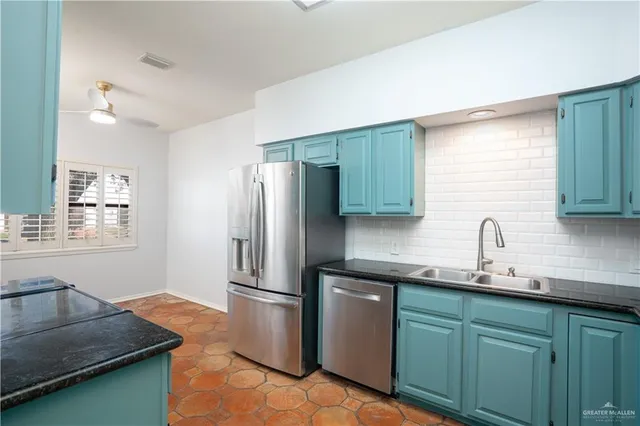 a kitchen with stainless steel appliances granite countertop a sink and a refrigerator