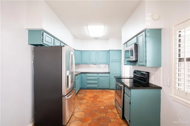 a kitchen with a refrigerator and a stove top oven