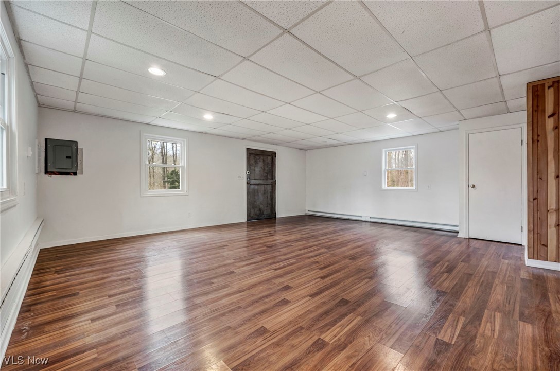 12150 Heath Road Chesterland, OH 44026 - Photo 28 of 43 Basement featuring a baseboard radiator, wood finished floors, a drop ceiling, and baseboards