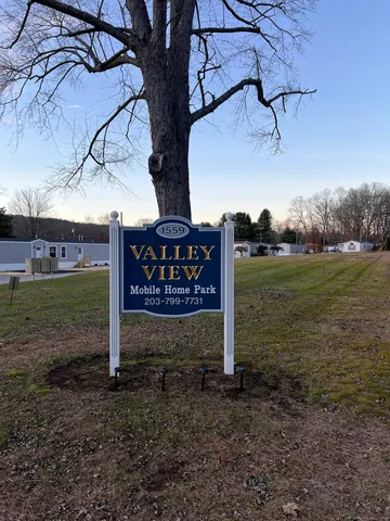 a view of a street sign under a large tree