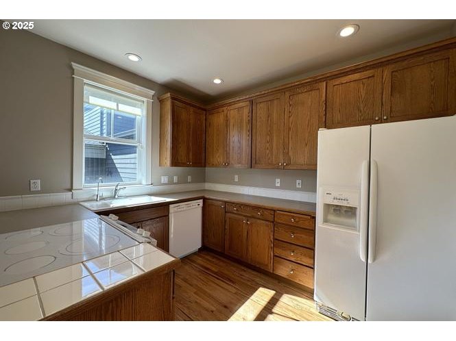 1495 Northeast Village Street Fairview, OR 97024 - Photo 6 of 16 a kitchen with granite countertop a refrigerator and a sink