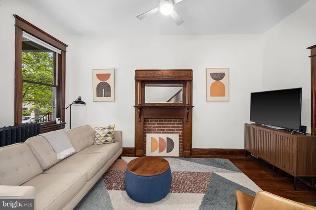 a living room with furniture a flat screen tv and a fireplace