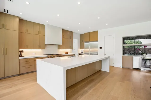 a large kitchen with kitchen island a sink stainless steel appliances and cabinets