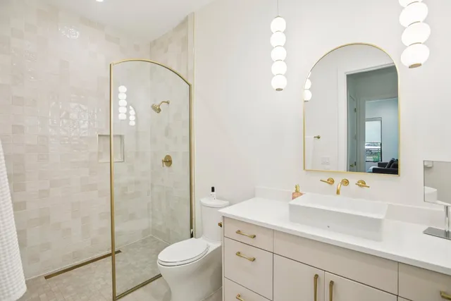 a bathroom with a sink a toilet and shower