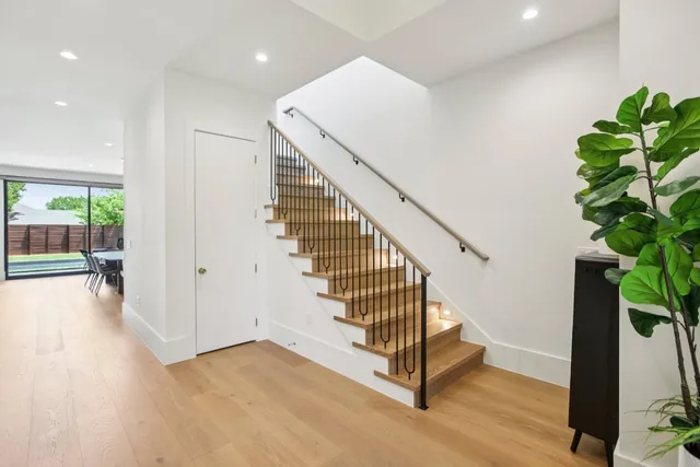 a view of a hallway with wooden floor and stairs