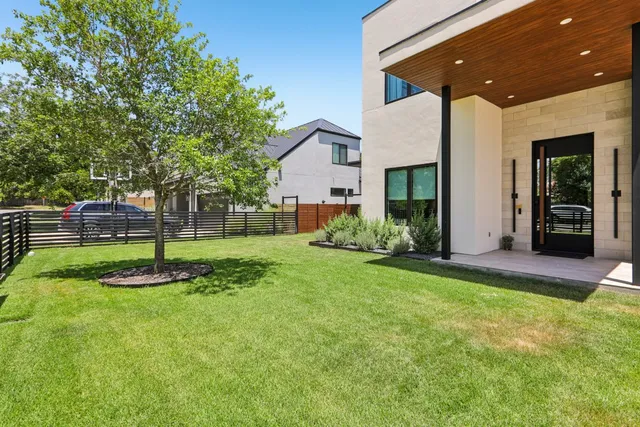 a view of a house with backyard and a tree