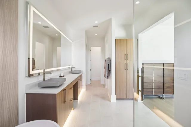 a bathroom with a granite countertop sink a toilet a mirror and shower