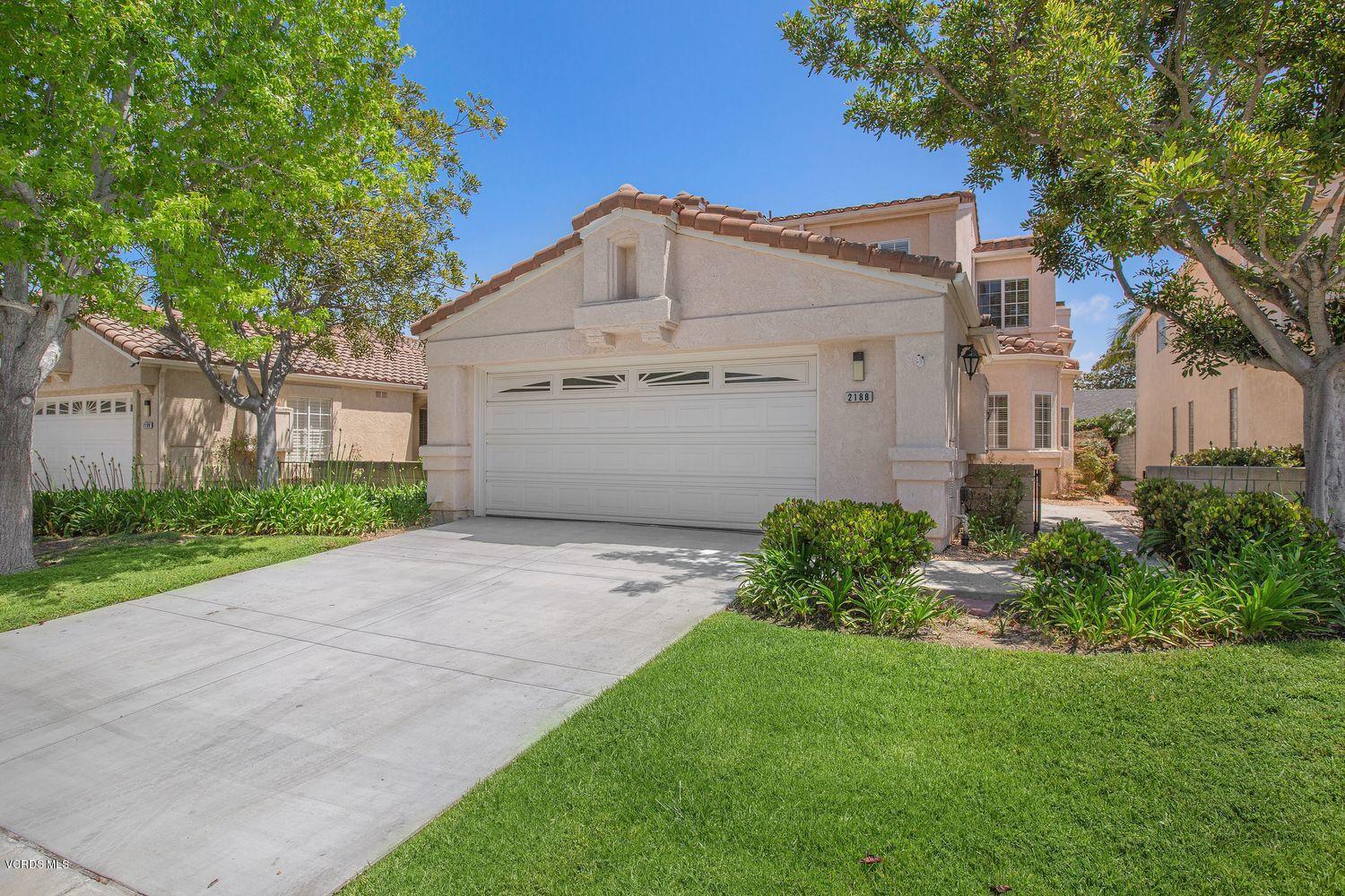 2188 Eastridge Loop Oxnard, CA 93036 - Photo 1 of 27 a view of a white house with a small yard and large tree