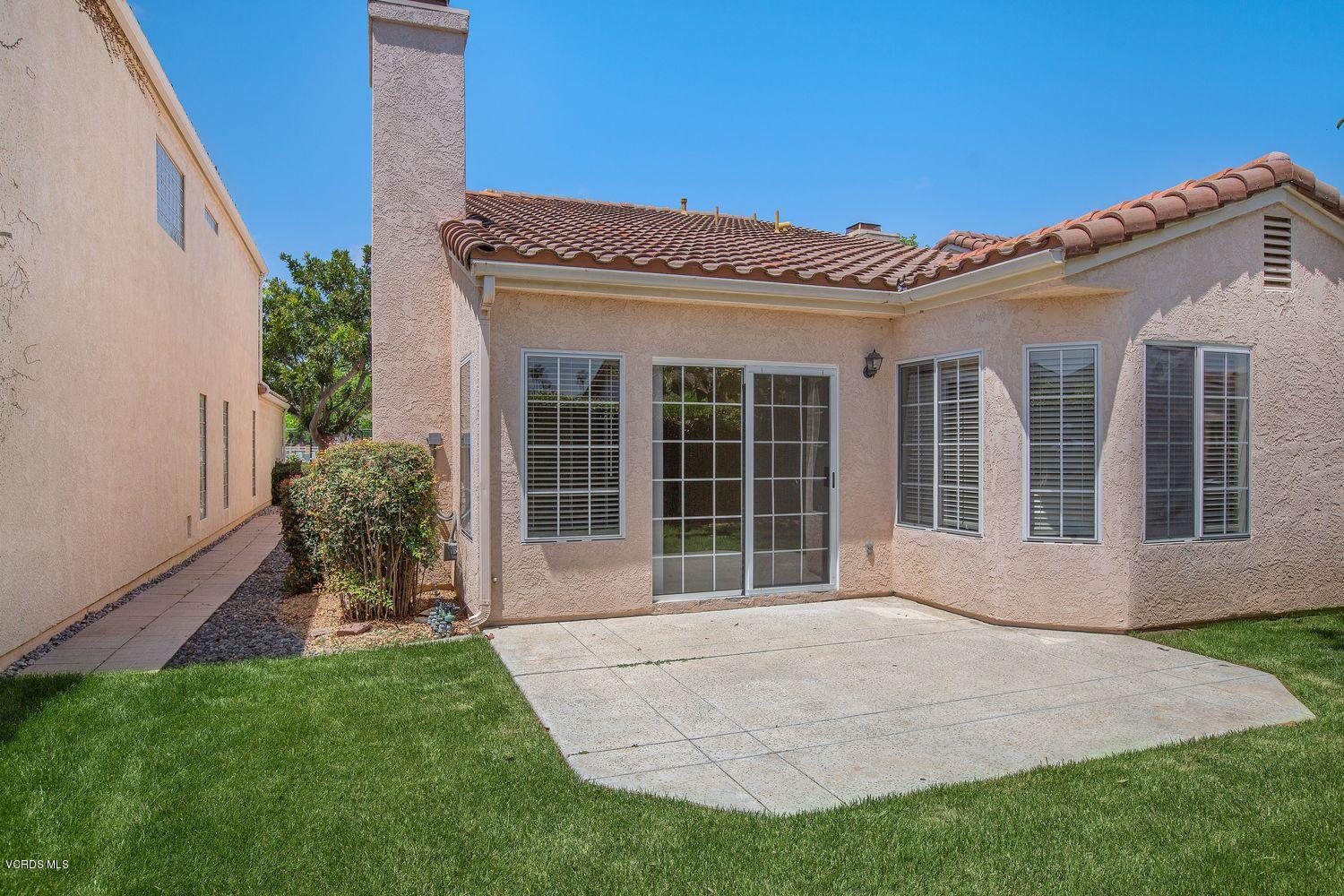 2188 Eastridge Loop Oxnard, CA 93036 - Photo 23 of 27 a front view of a house with a garden and yard