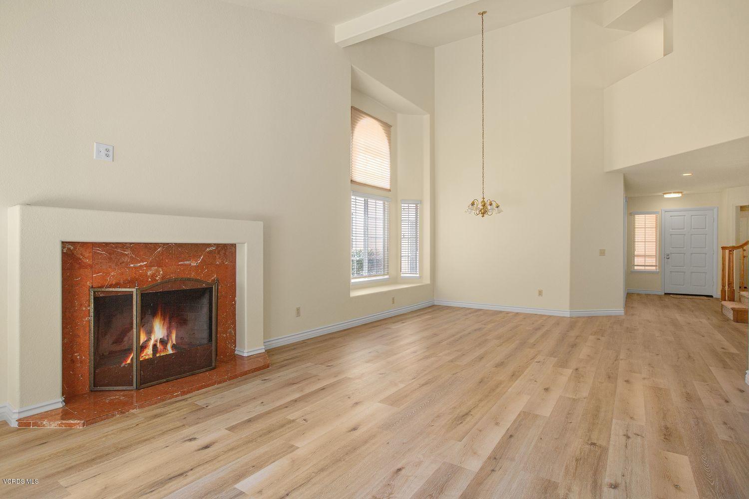 2188 Eastridge Loop Oxnard, CA 93036 - Photo 5 of 27 a view of an empty room with wooden floor fireplace and a window