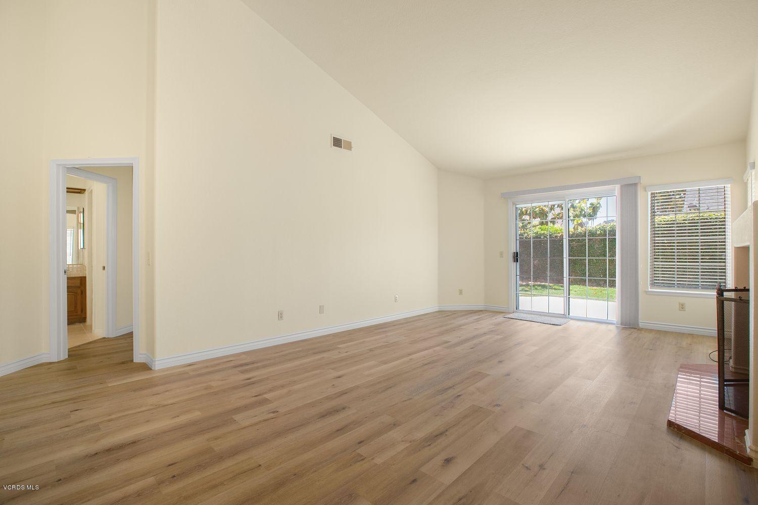 2188 Eastridge Loop Oxnard, CA 93036 - Photo 6 of 27 a view of an empty room with wooden floor and a window
