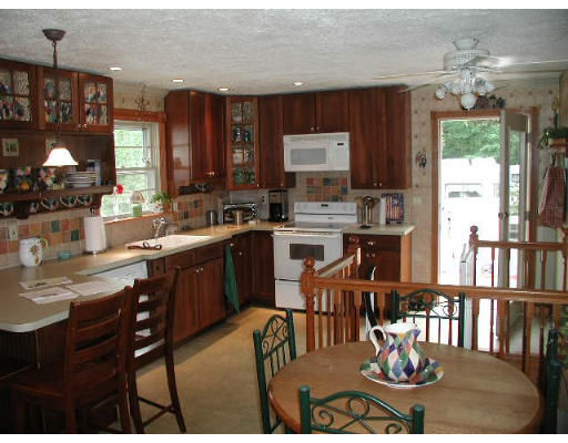 74 Longley Road Shirley, MA 01464 - Photo 3 of 4 a kitchen with a stove a sink a dining table and chairs