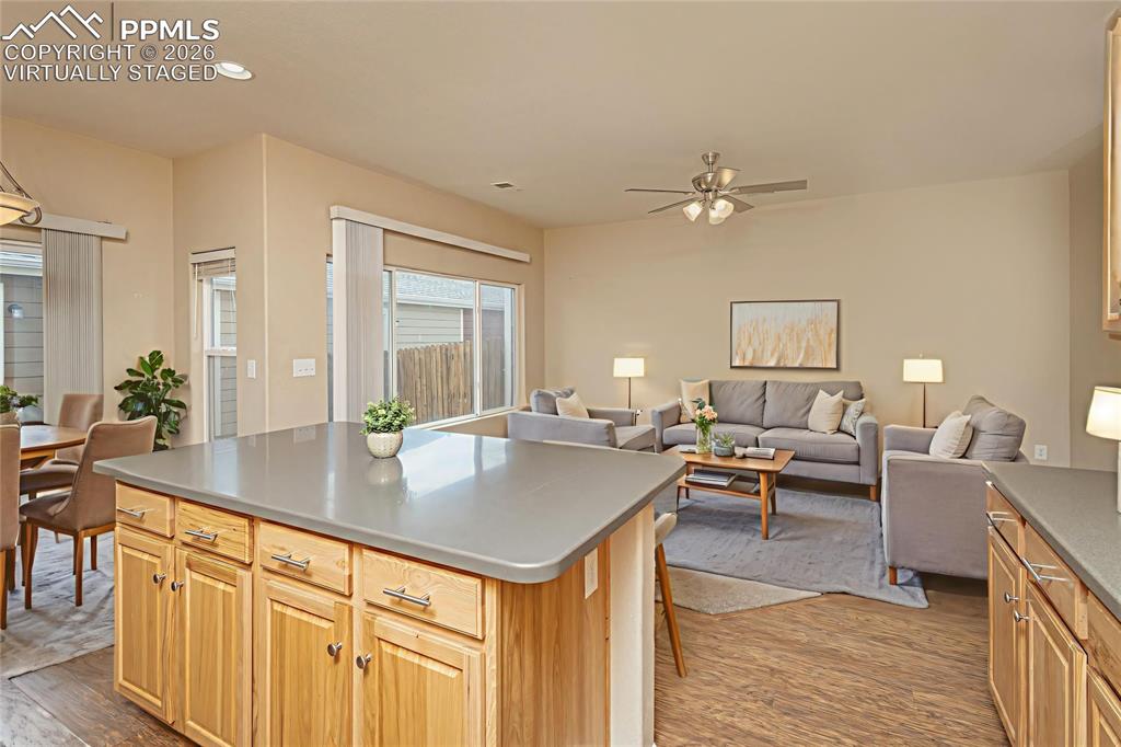 4815 Harrier Ridge Drive Colorado Springs, CO 80916 - Photo 10 of 33 Kitchen with a kitchen island, open floor plan, ceiling fan, light wood finished floors, and recessed lighting Virtually Staged