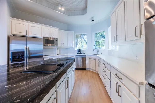 a kitchen with kitchen island granite countertop a sink appliances cabinets and counter space