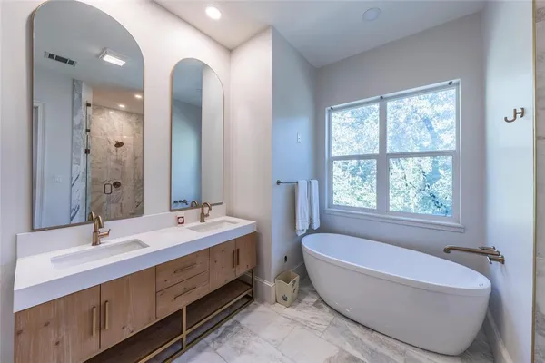 a spacious bathroom with sink shower bathtub and mirror