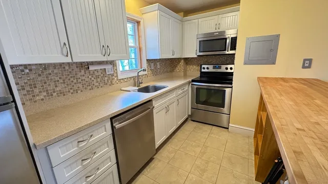 a kitchen with stainless steel appliances a stove a sink a microwave and cabinets