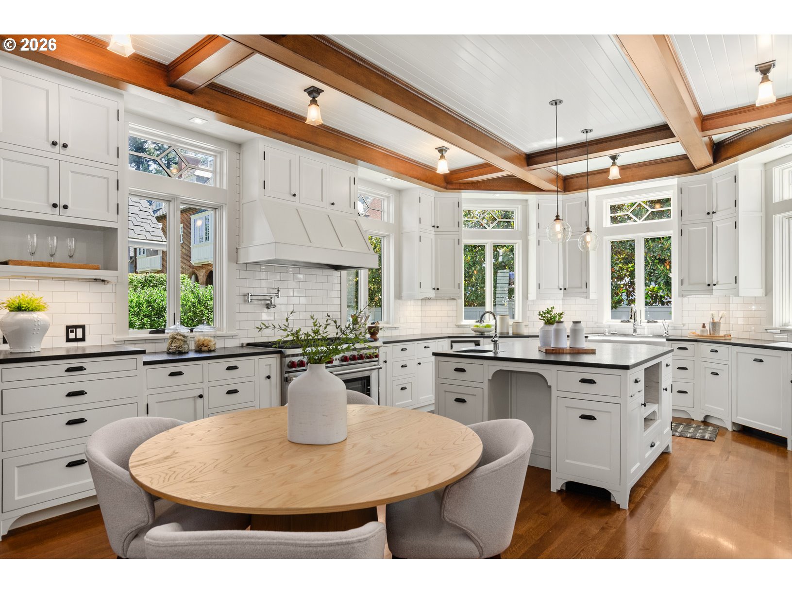 2023 Southwest Montgomery Drive Portland, OR 97201 - Photo 7 of 46 a kitchen with stainless steel appliances granite countertop a stove a sink dishwasher and white cabinets with wooden floor