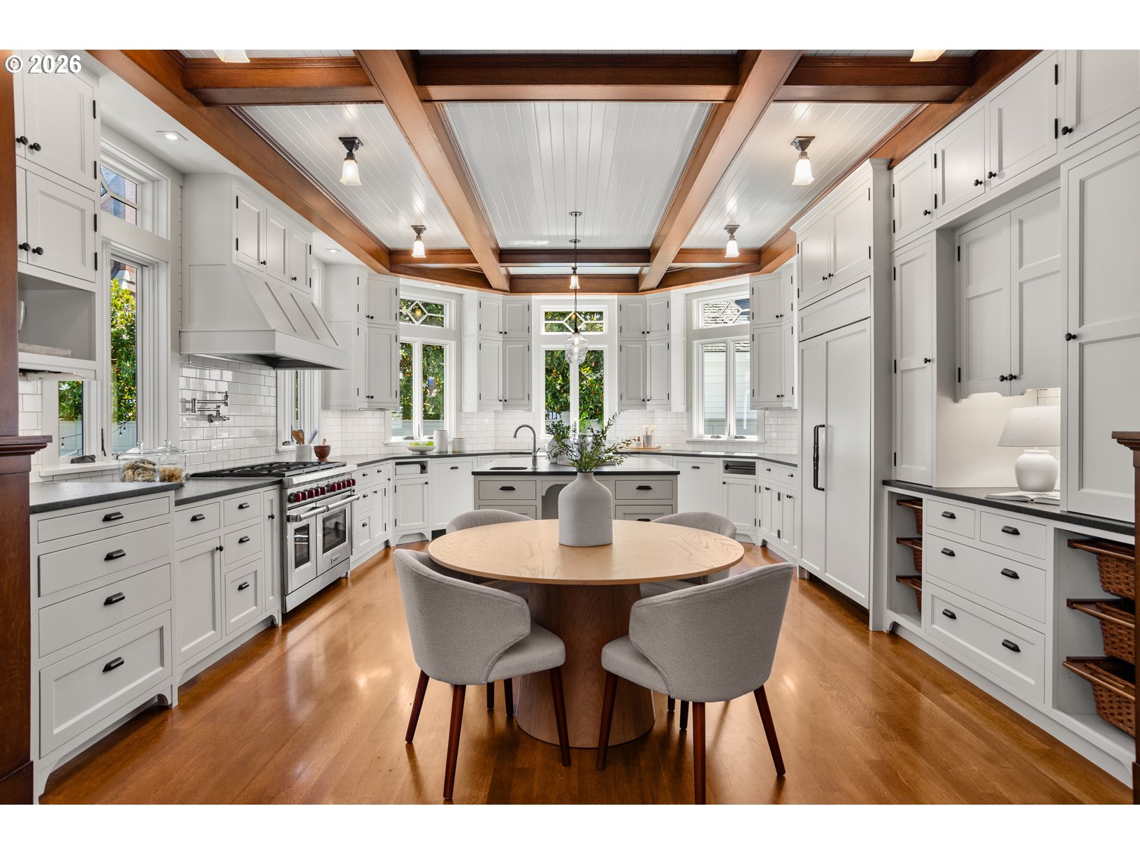 2023 Southwest Montgomery Drive Portland, OR 97201 - Photo 8 of 46 a kitchen with stainless steel appliances kitchen island granite countertop a table chairs and white cabinets