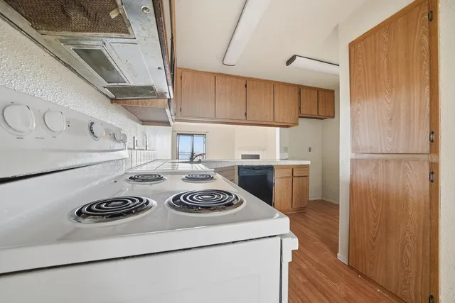 a kitchen with cabinets stainless steel appliances and wooden floor