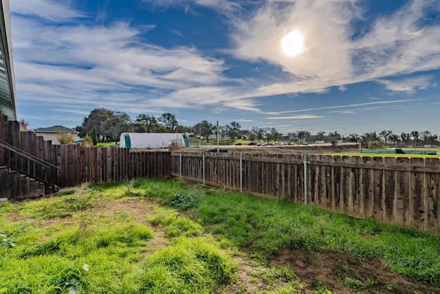 a view of a yard with wooden fence