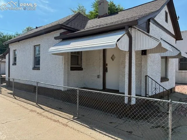 a view of a house with a wooden fence