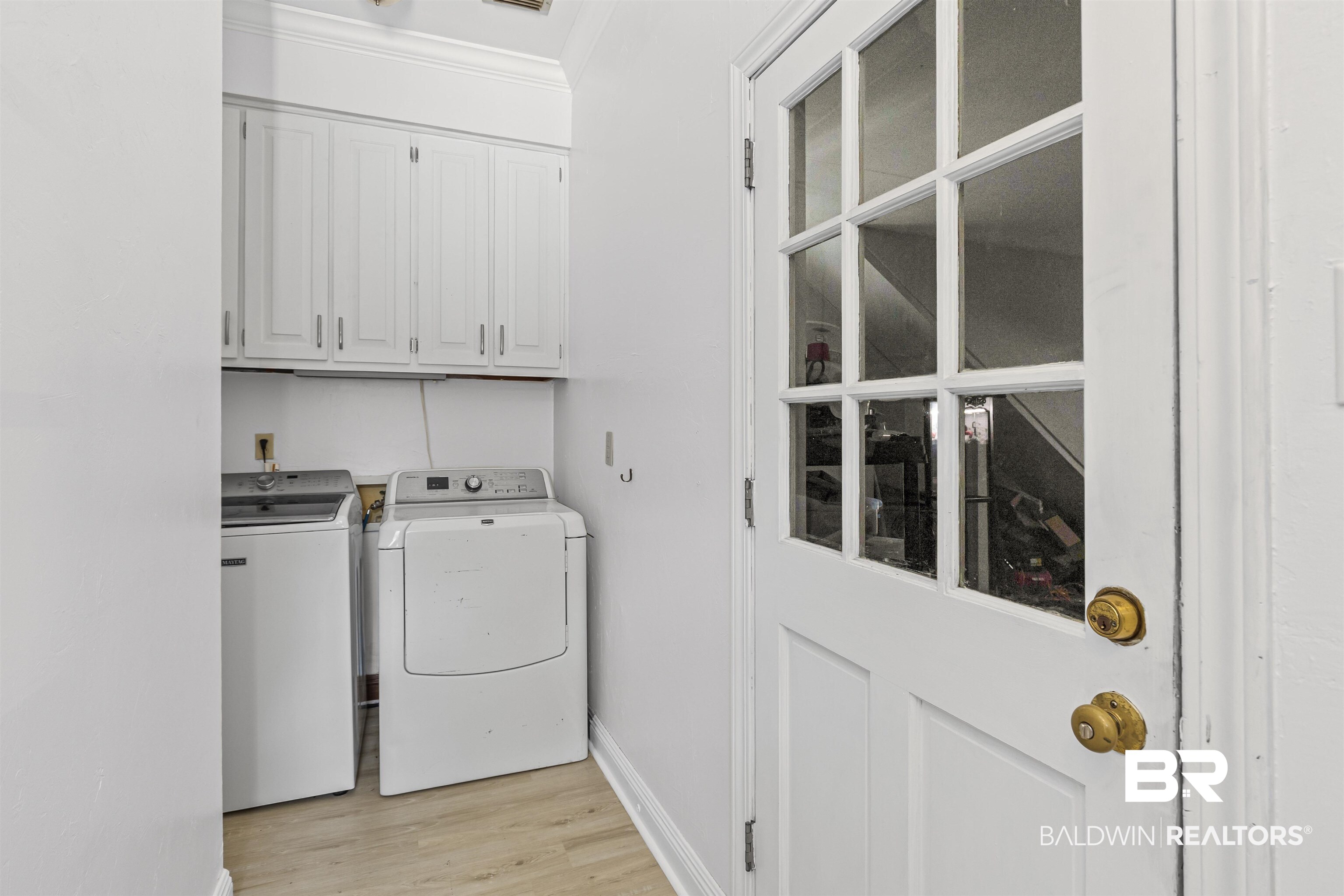 5324 Oak Bend Court Mobile, AL 36609 - Photo 17 of 49 Laundry room featuring crown molding, light wood-style flooring, cabinet space, and washing machine and clothes dryer