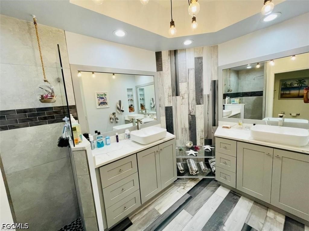 14971 Rivers Edge Court, Unit 101 Fort Myers, FL 33908 - Photo 8 of 9 a bathroom with a double vanity sink mirror and shower