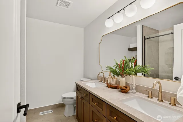 a bathroom with a granite countertop sink a toilet and mirror
