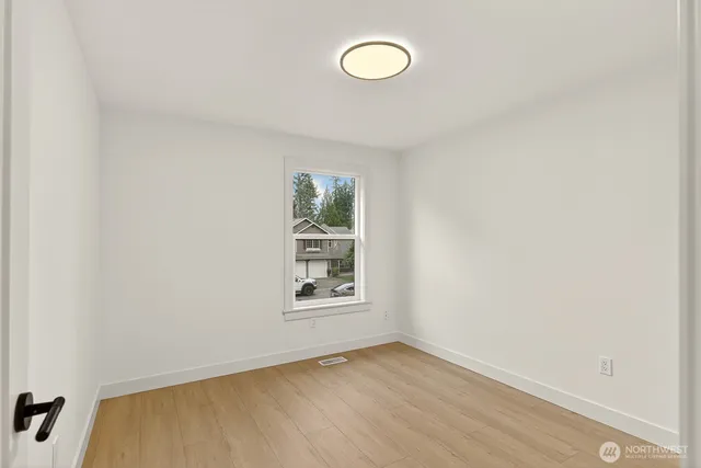 a front view of a house with a yard and tree