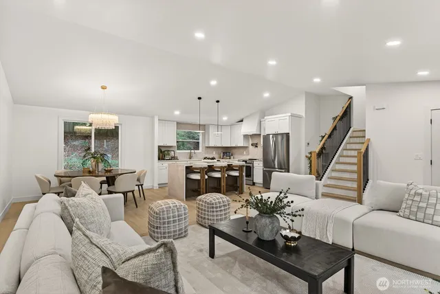 a living room with furniture kitchen view and a wooden floor