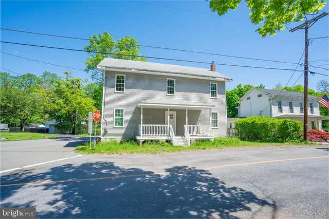 a front view of a house with a yard and potted plants