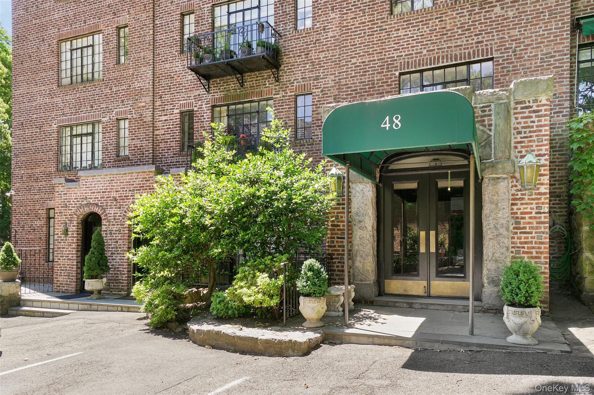 48 Sagamore Road, Unit 30 Bronxville, NY 10708 - Photo 1 of 1 View of exterior entry with brick siding, french doors, and uncovered parking