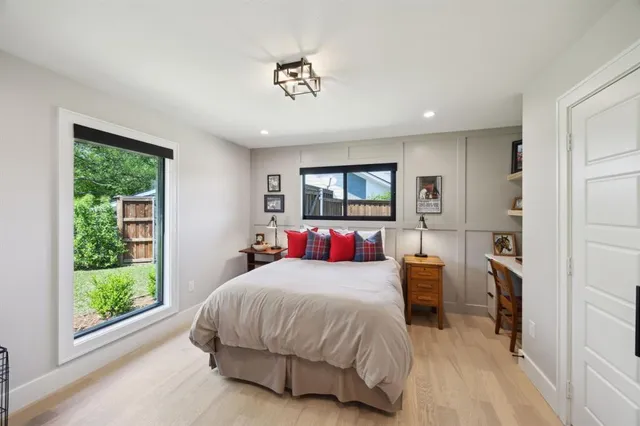 a bedroom with a large bed and a flat tv screen