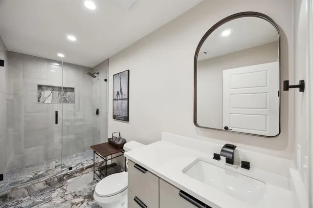 a bathroom with a sink a toilet and shower