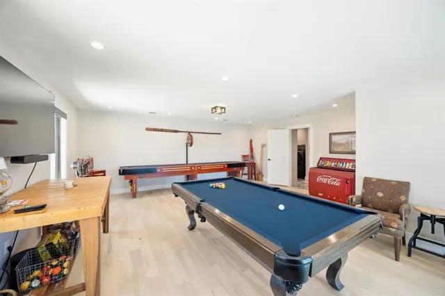 a room with furniture pool table and window