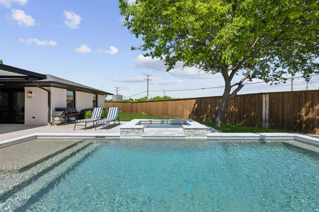 a large kitchen with stainless steel appliances a large counter top a stove and a refrigerator