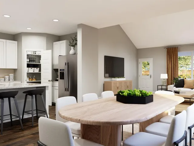 a kitchen with stainless steel appliances kitchen island granite countertop a dining table chairs and a refrigerator