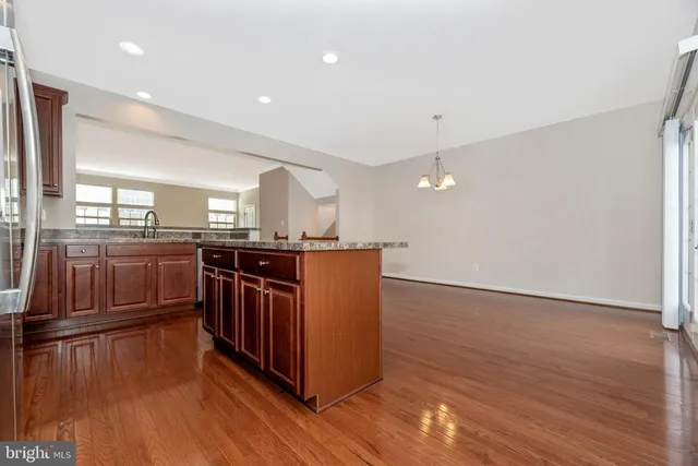 a kitchen with stainless steel appliances granite countertop a stove a sink and a wooden floors