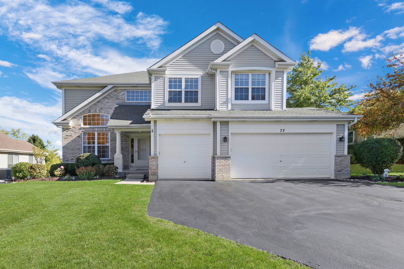 a front view of a house with a yard and garage