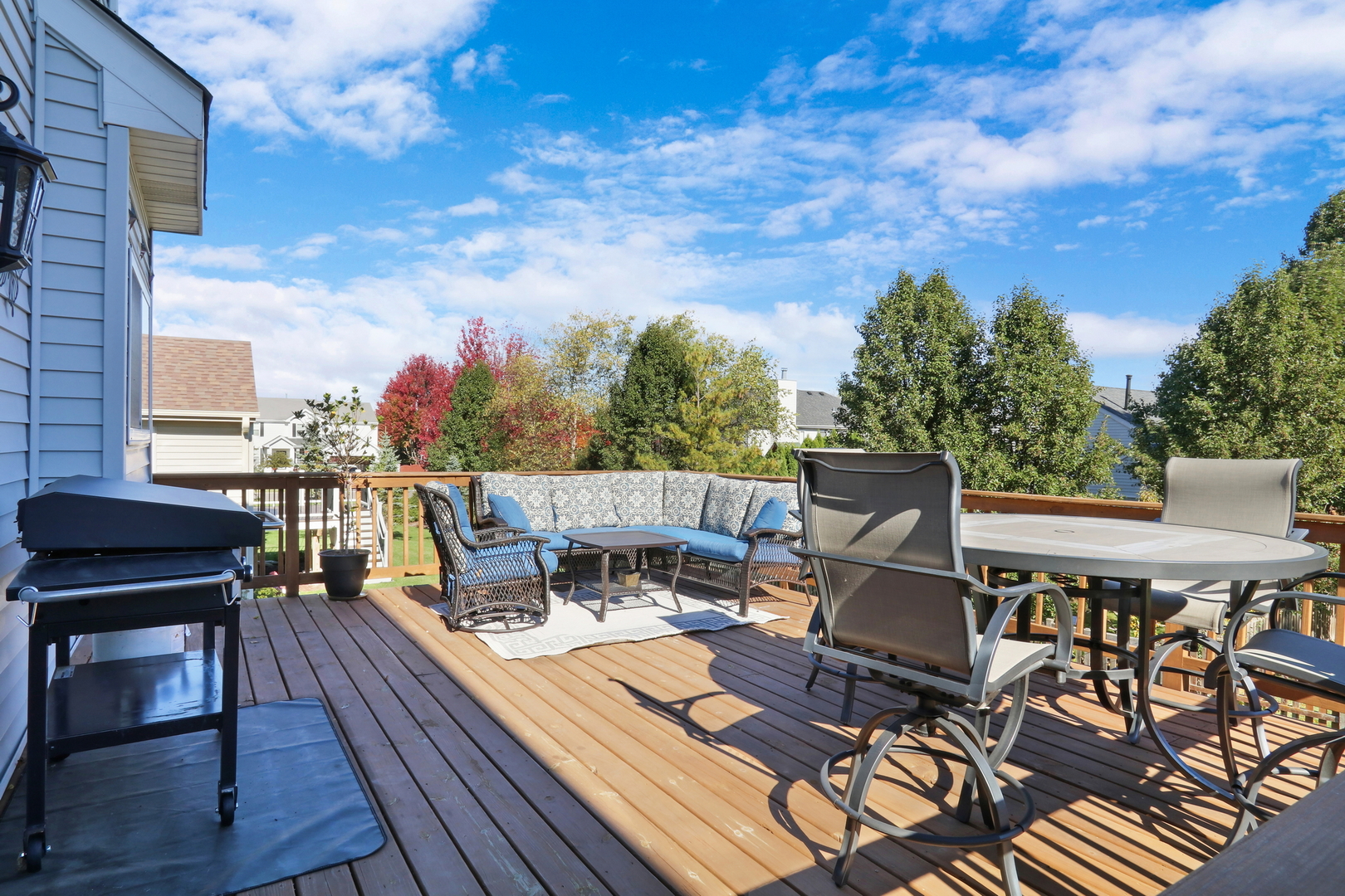 77 Bridle Path Drive Lindenhurst, IL 60046 - Photo 43 of 52 a view of a roof deck with table and chairs a barbeque with wooden floor and fence