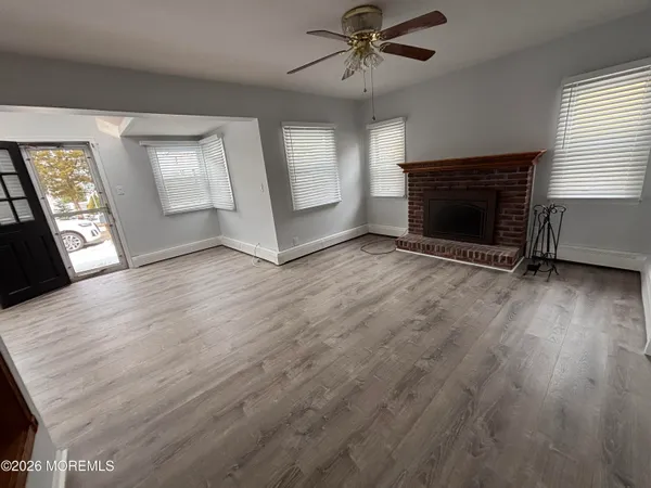 an empty room with windows and fireplace
