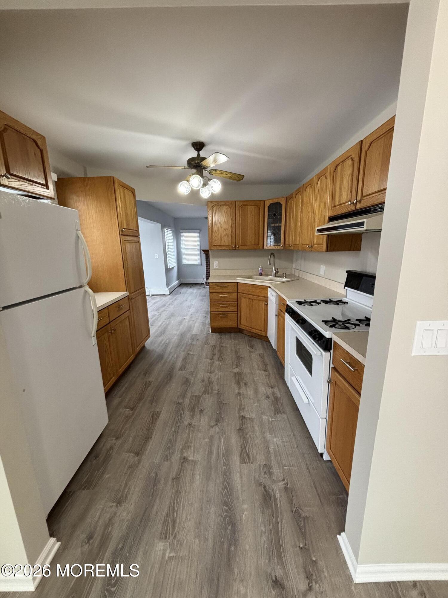 507 Riverside Drive South Brick, NJ 08723 - Photo 9 of 17 a kitchen with granite countertop a stove top oven a sink dishwasher and a refrigerator with wooden floor