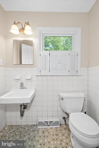 a bathroom with a sink a toilet and mirror