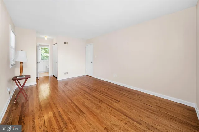 a view of a room with wooden floor and bench